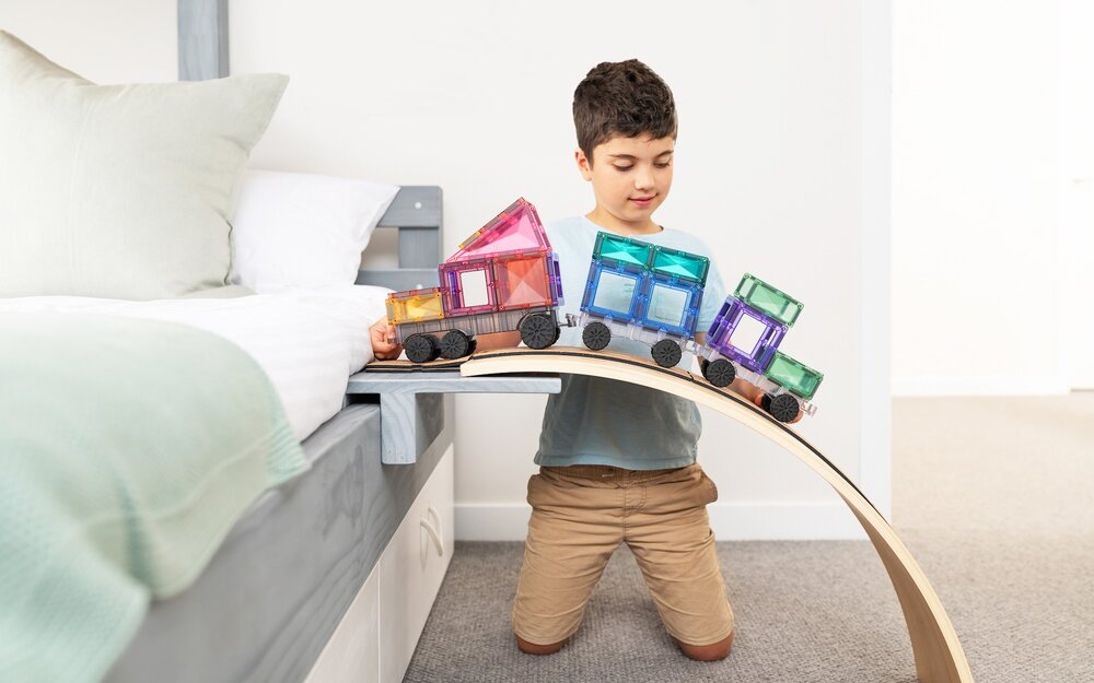 Kind speelt met Connetix Magnetische Tegels &ndash; pastel voertuig op tafel