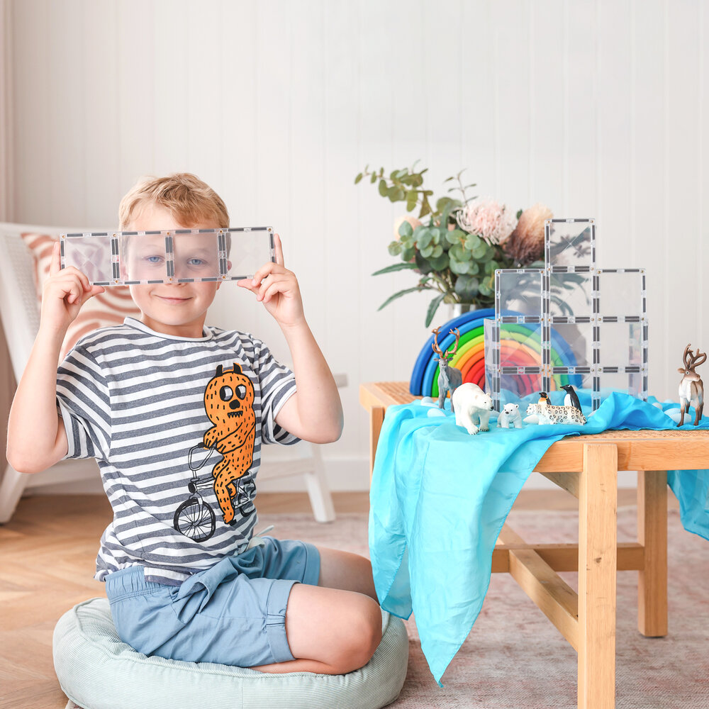 Kind speelt met Connetix Magnetische Tegels &ndash; licht schijnt door bouwwerk