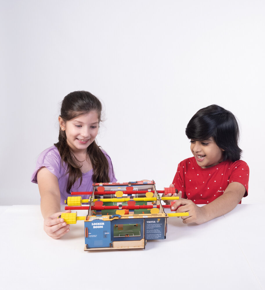 Kinderen spelen samen tafelvoetbal met Smartivity houten bouwset